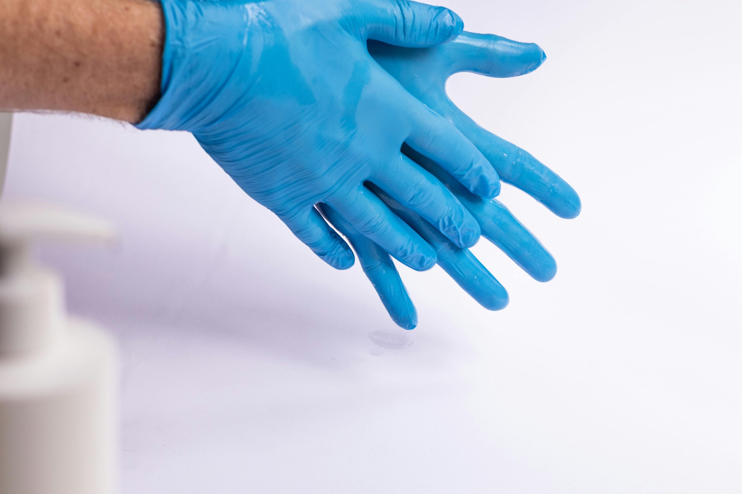 Mains portant des gants jetables bleus pour garantir une hygiène optimale et prévenir les contaminations.